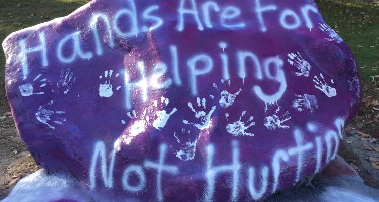 Kent State rock painted with the words "Hands are for helping, not hurting"