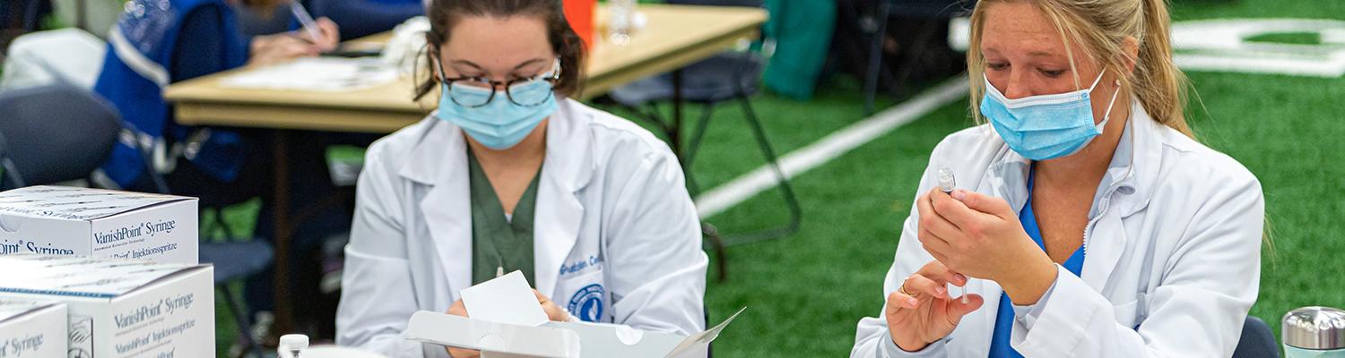 Medical professionals assist with vaccinations at the Kent State Field House