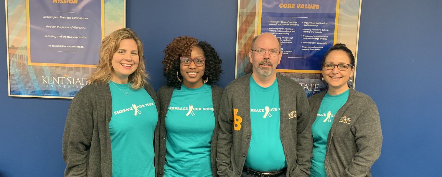 group photo of 4 individuals wearing Sexual Assault Awareness Month shirts