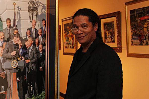 Georgio Sabino III at his exhibition of photography standing in front of a photograph of President Barack Obama.