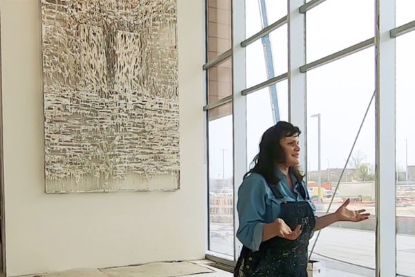 Alumna Diana Al-Hadid speaking in front of her artwork installed at Summa Health Systems